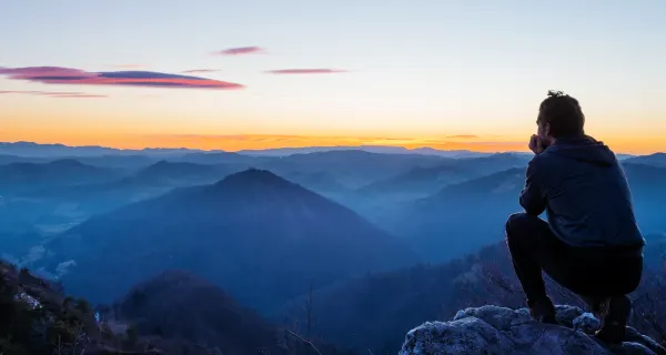 man on mountain at sunset